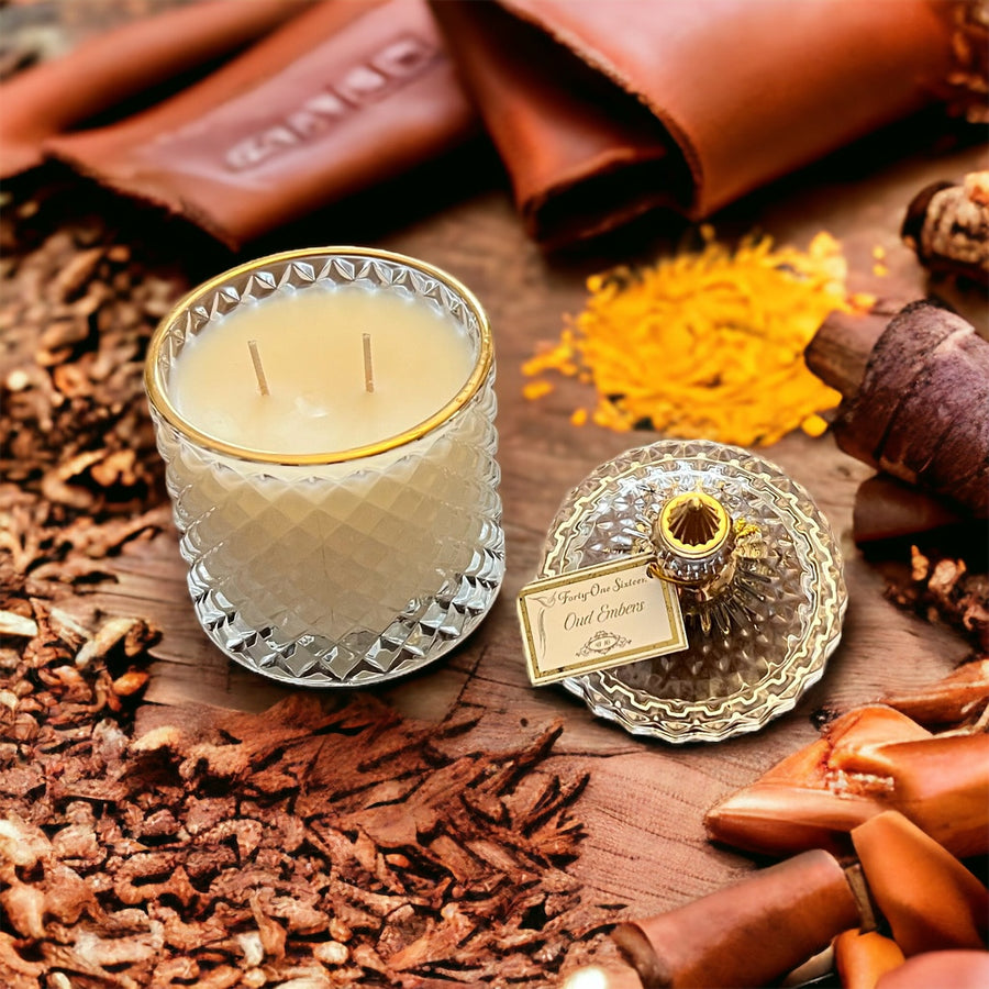 Oud Embers scented candle in clear glass jar with gold label
