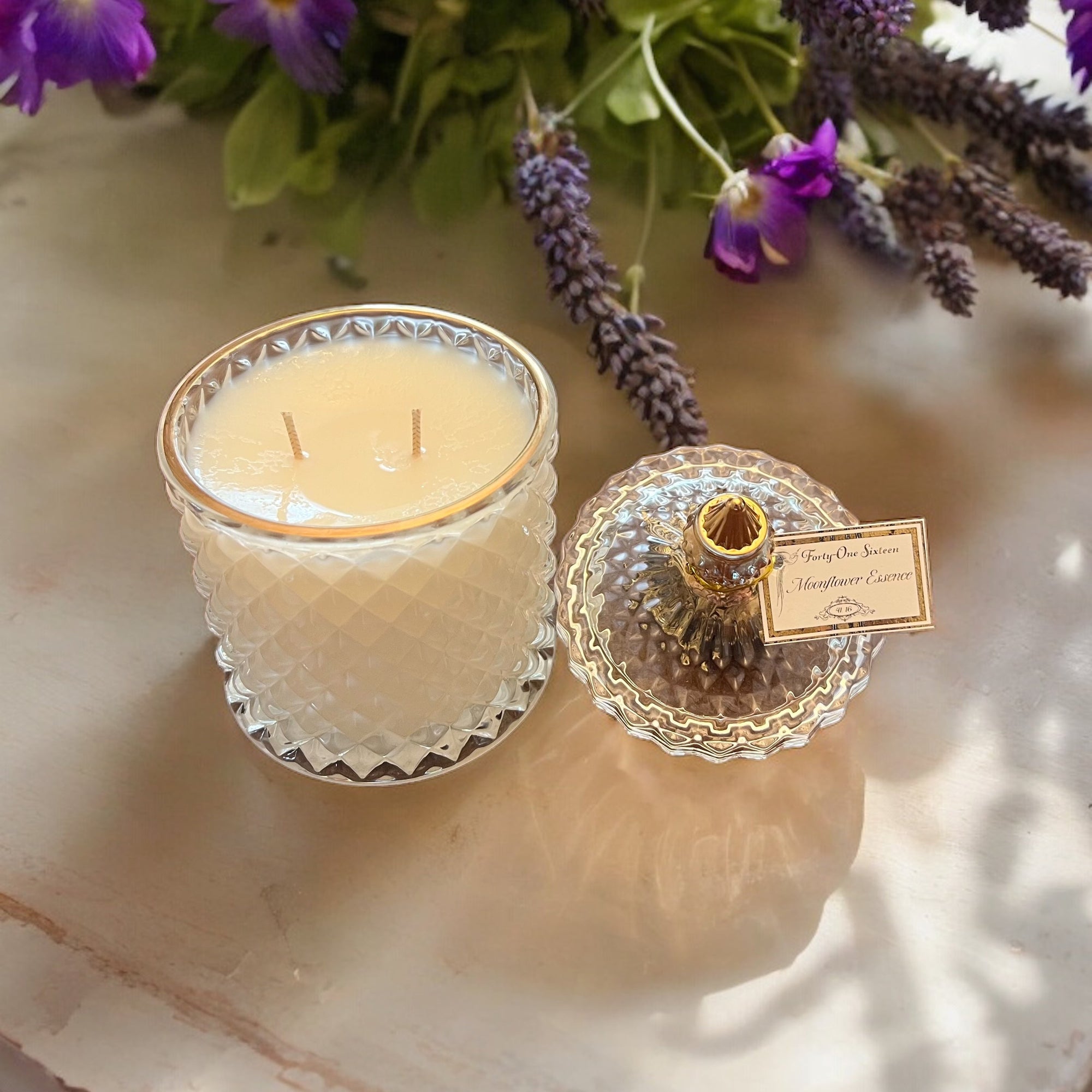 Moonflower Essence scented candle in clear glass jar with gold label
